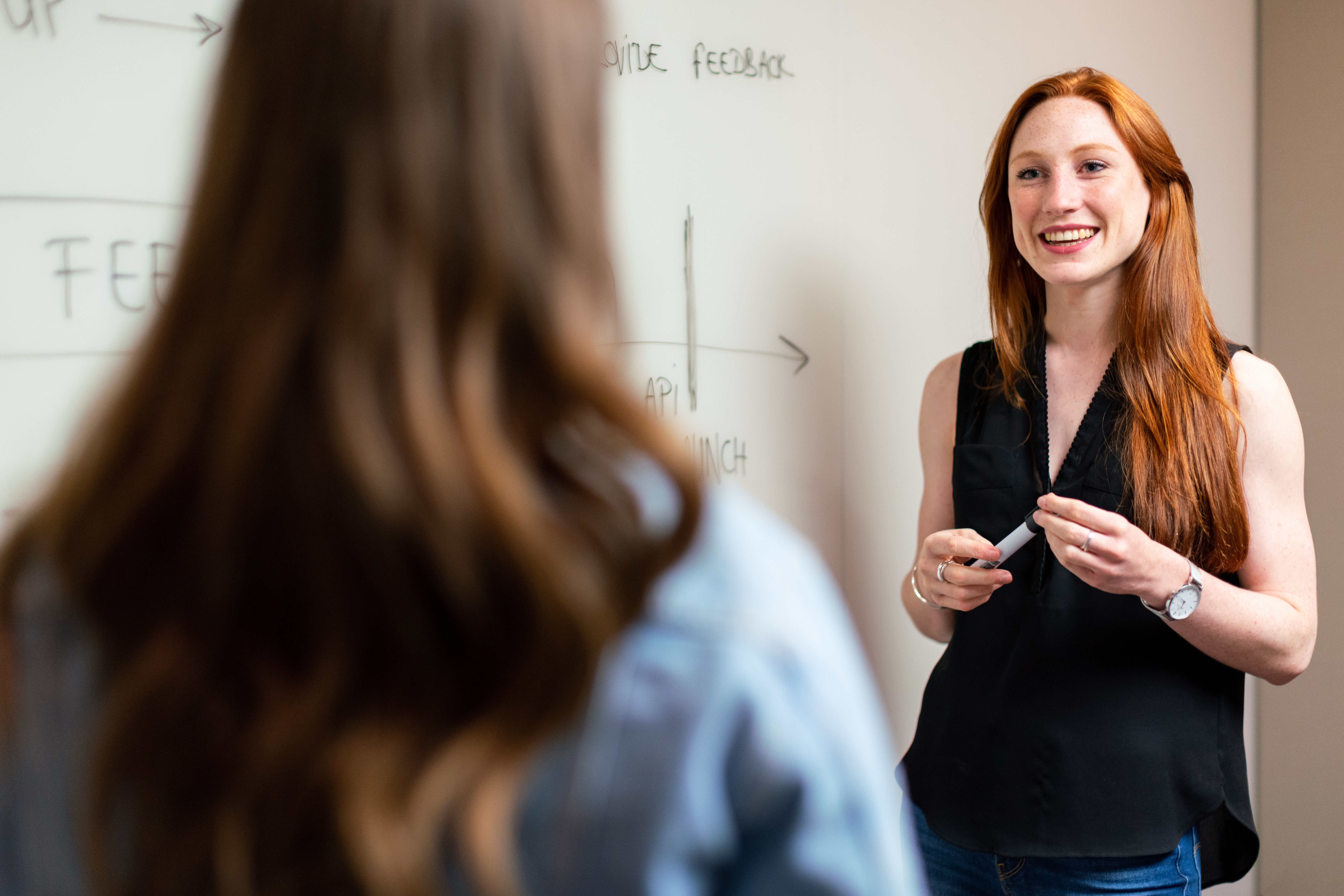 Teacher standing in front of a whiteboard.